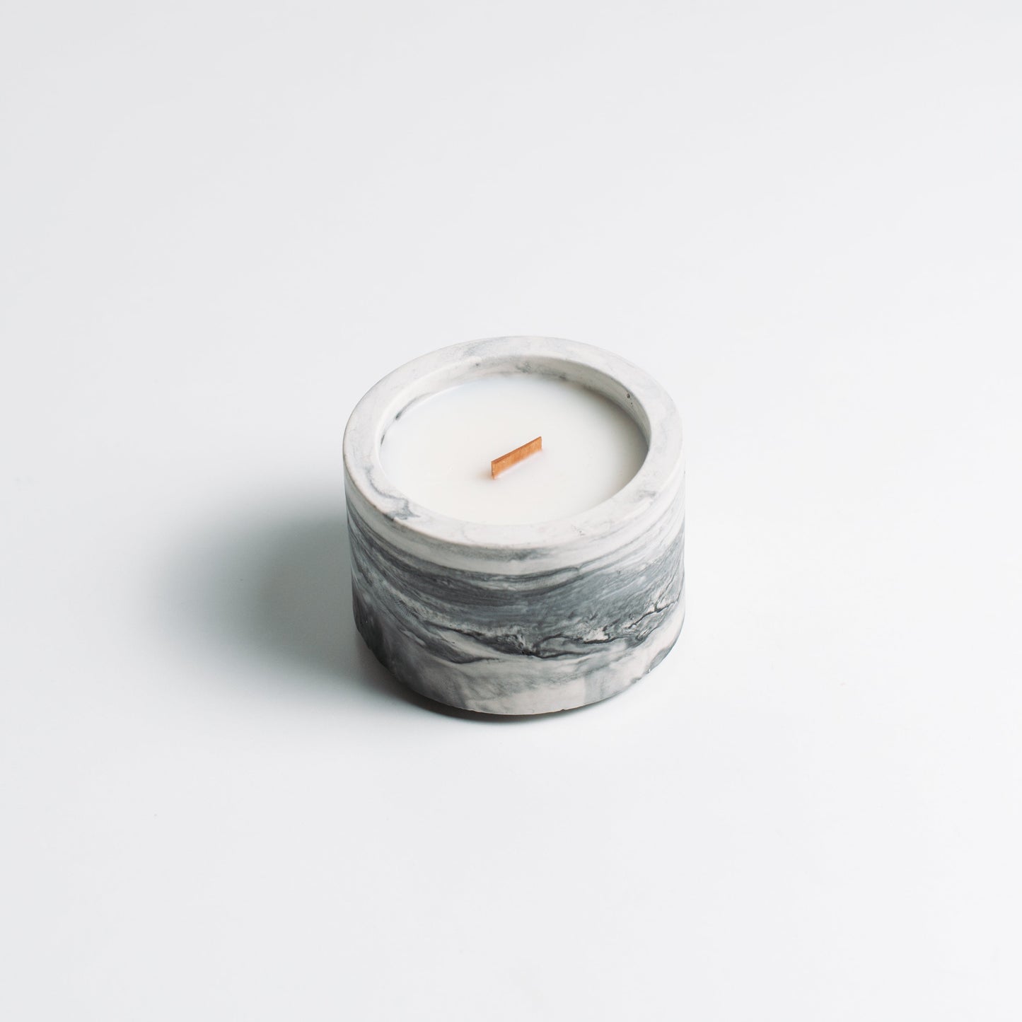 Marble-textured candle on a light gray background